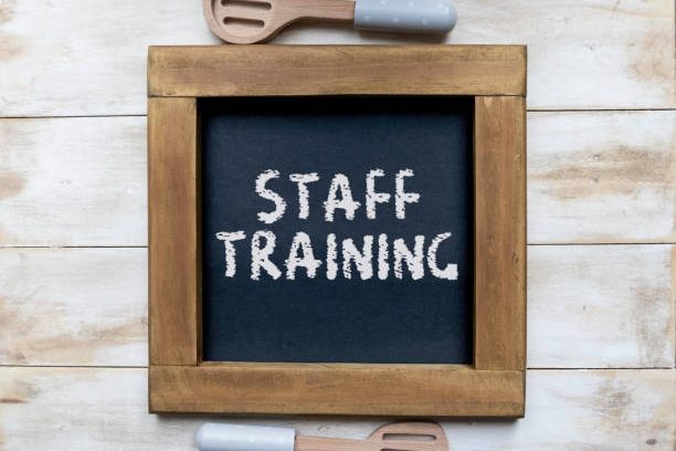 Wooden frame with a chalkboard displaying the words "STAFF TRAINING."