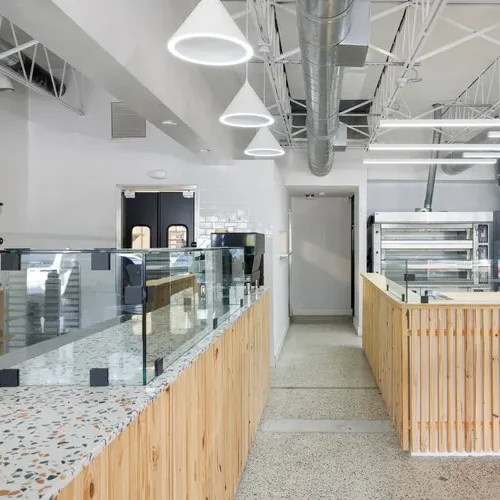 Modern interior of a cafe with glass display cases and wooden accents.