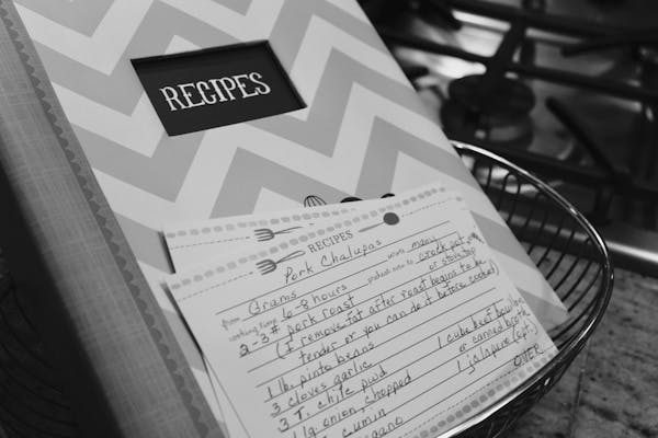 A chevron-patterned recipe binder with handwritten recipe cards inside.