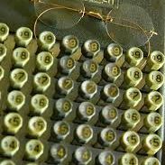 Close-up of an antique adding machine keypad with brass rimmed glasses.