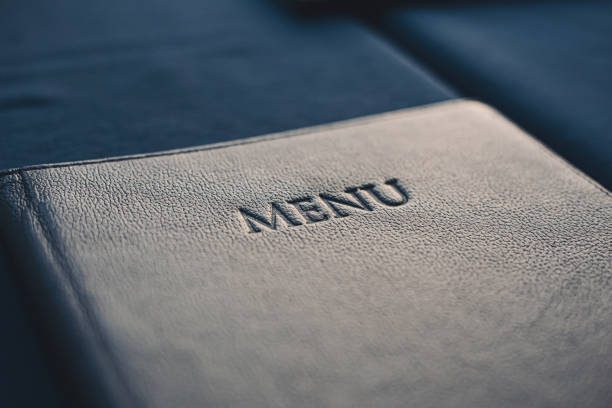 Close-up of a dark menu cover with the word "MENU" embossed on it.